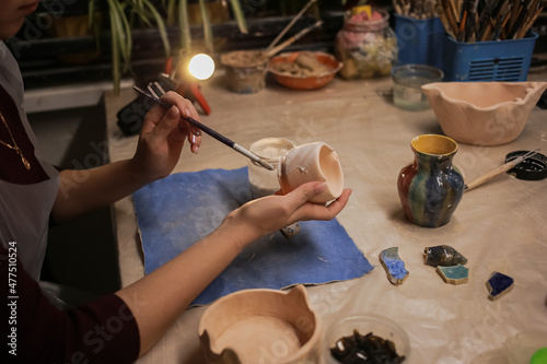 A human sculptor makes a clay product with his own hands photo