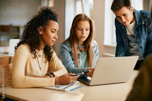 Fotografie Group of high school students cooperate while e-learning on laptop in classroom