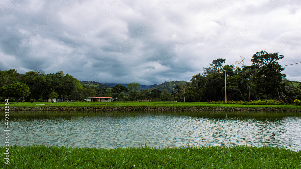 Paisaje de campo con lago y fondo verde con casa Paisaje de campo con lago y fondo verde con casa