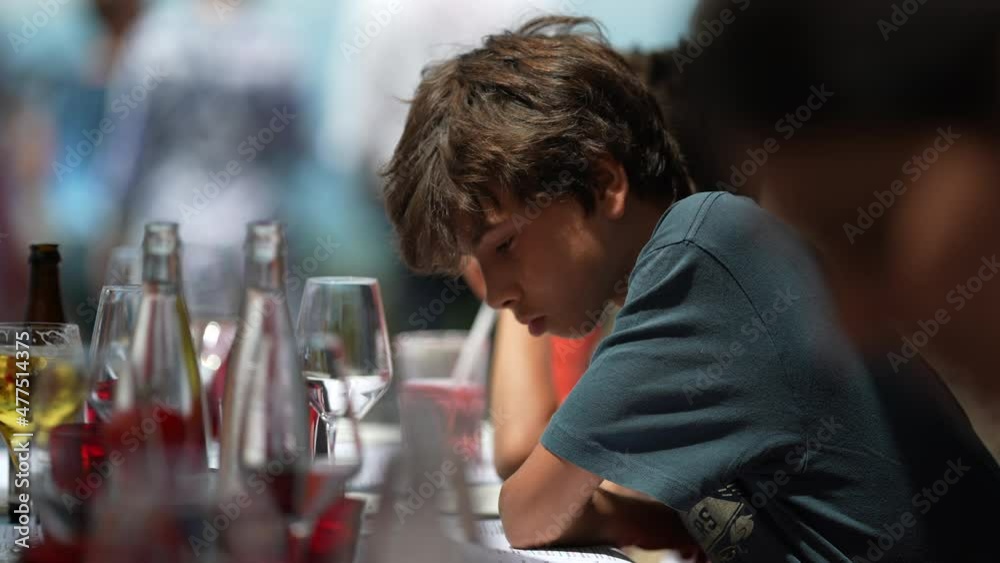 Pensive child sitting at restaurant. Thoughtful young boy Pensive child sitting at restaurant. Thoughtful young boy