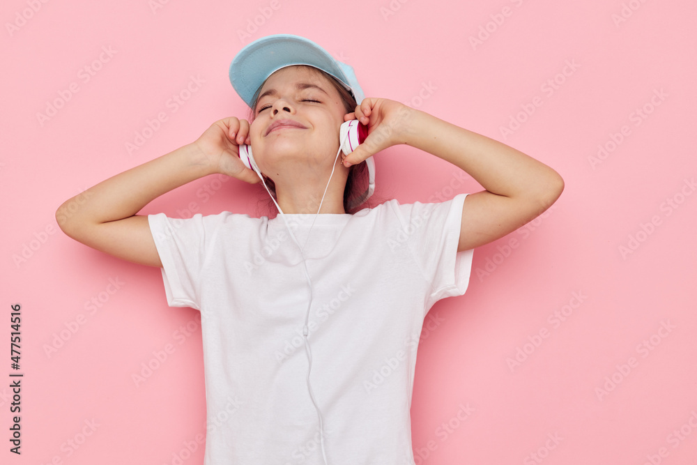 Portrait of happy smiling child girl listening to music on headphones isolated background