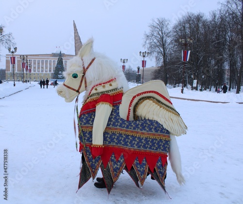 man in colorful unicorn costume on the city square at winter holiday photo