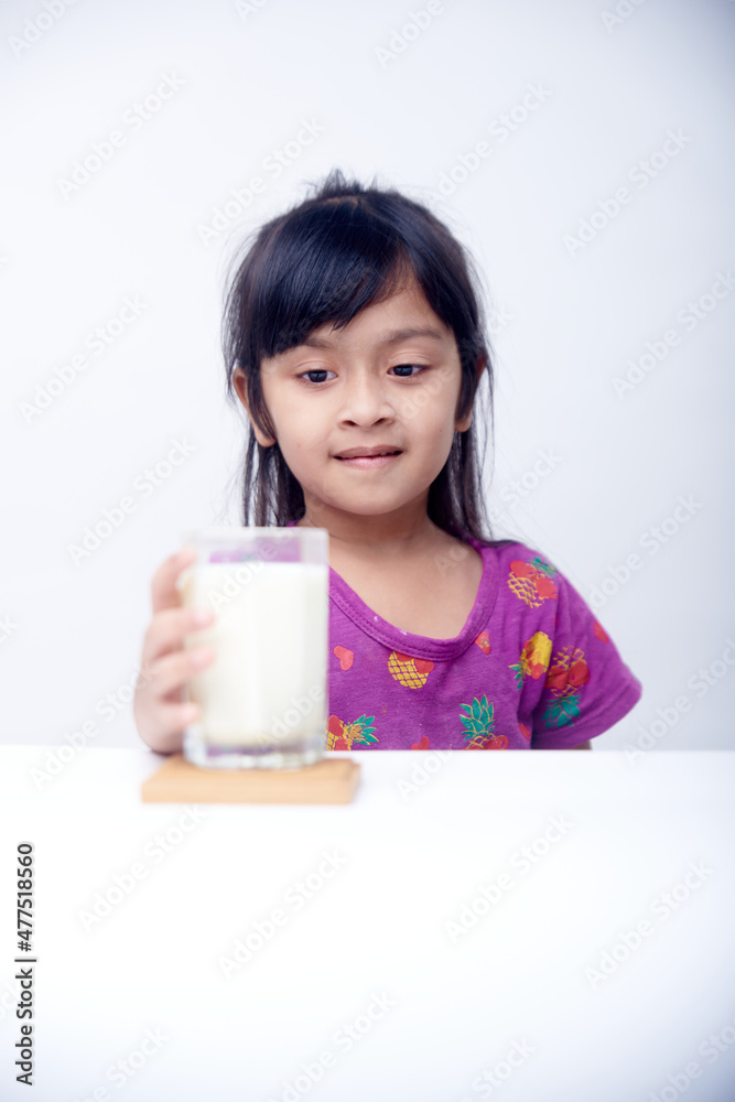 Healthy little Girl drinking a glass of milk on White background