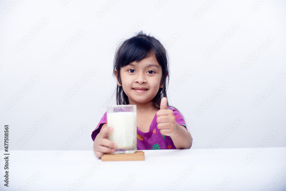 Healthy little Girl drinking a glass of milk on White background