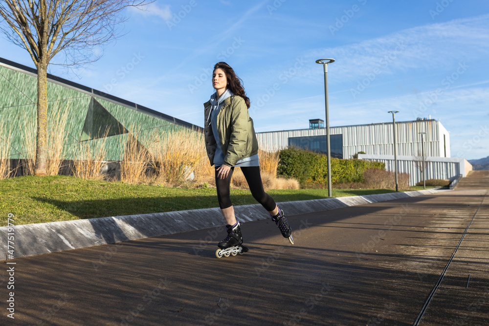 Woman skating / rollerblading in a modern area.