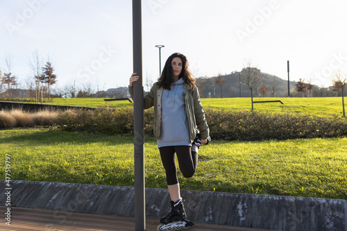Inline skater woman stretching. Rollerblading girl photo