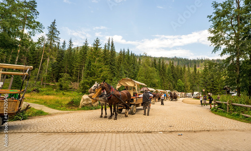 Brzegi, Poland - August 14, 2021: Parking for horse carriage on the road to Lake Morskie Oko at entrance to Tatra National Park © Arpan