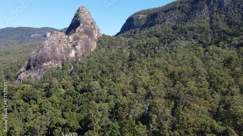 Arial perspective of towering mountain peaks obscured by dense rainforest