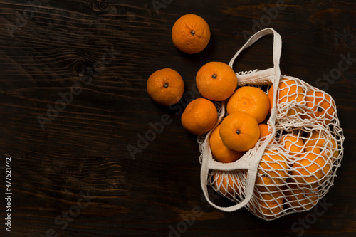 Wallpaper Mural Fresh mandarin oranges fruit or tangerines on a wooden table. Christmas composition. Mandarin oranges in organic cotton mesh bag. Grocery shopping fabric net bag. No plastic bag. Torontodigital.ca