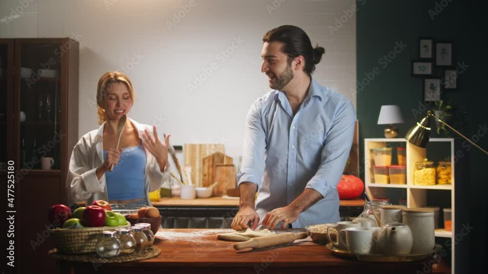 Loving couple, man and woman dancing and singing in kitchen. Young husband and wife having fun. Cooking family dinner together and playing. Romantic relationships. Loving couple, man and woman dancing and singing in kitchen. Young husband and wife having fun. Cooking family dinner together and playing. Romantic relationships.