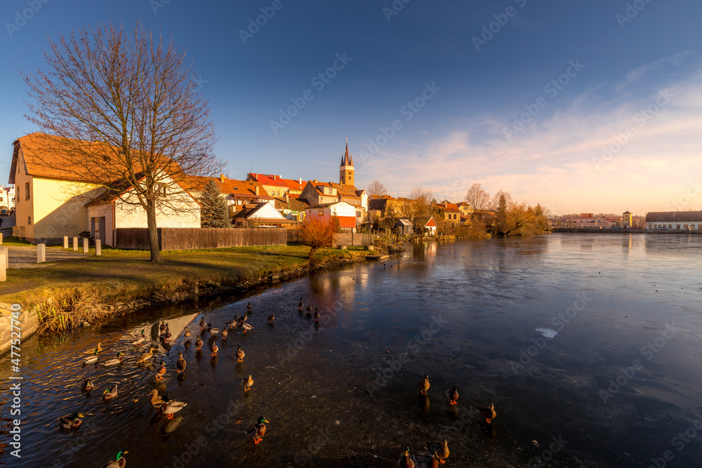 Fototapeta premium Castle Park and Telc Castle. View of the city of Telc in the winter sunset. The picturesque castle and the historic center with the decorative facades of the houses belong to the UNESCO World Heritage
