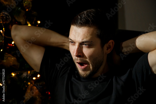 Tired man stretching yawns feeling sleepy. Lack of sleep. New Year's Eve