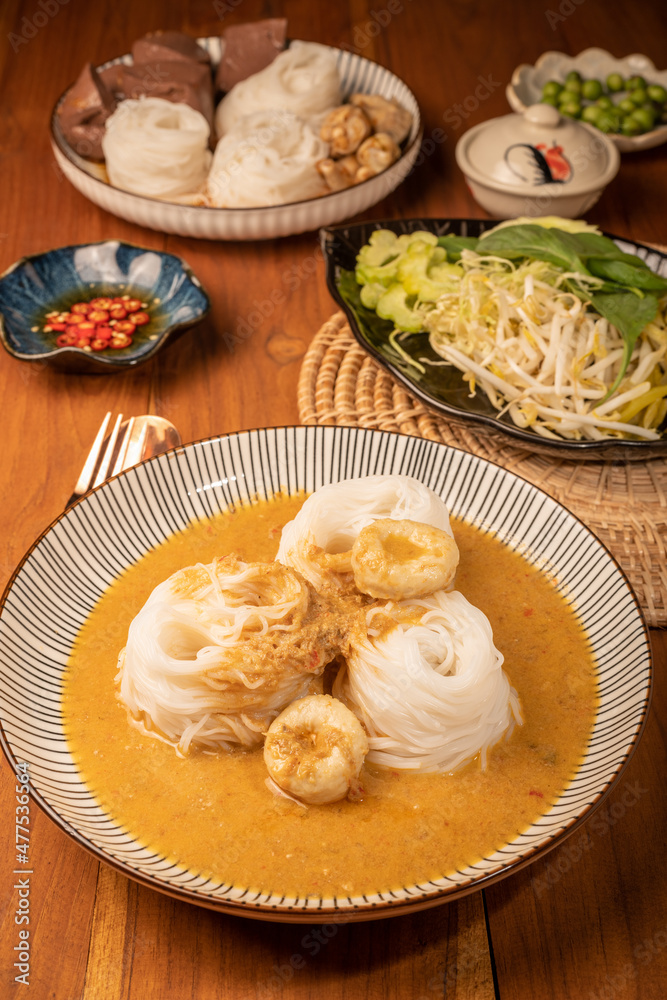 Rice noodles or Kkanomjeen namya krati in fish curry sauce with vegetables, Rice vermicelli with minced fishes and coconut milk in red curry.