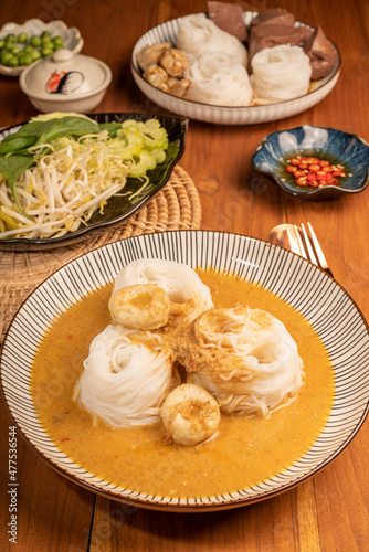 Rice noodles or Kkanomjeen namya krati in fish curry sauce with vegetables, Rice vermicelli with minced fishes and coconut milk in red curry.