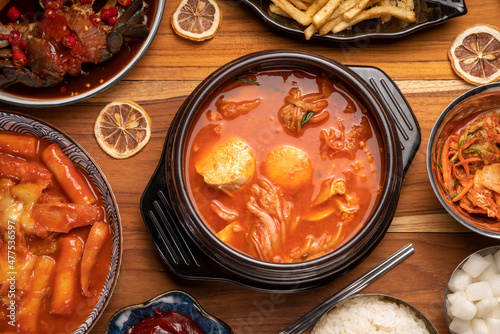  Korean traditional Kimchi soup with Tofu mushroom hot pot, Kimchi soup in hot iron pot with rice and Kimchi pickle on wooden table,