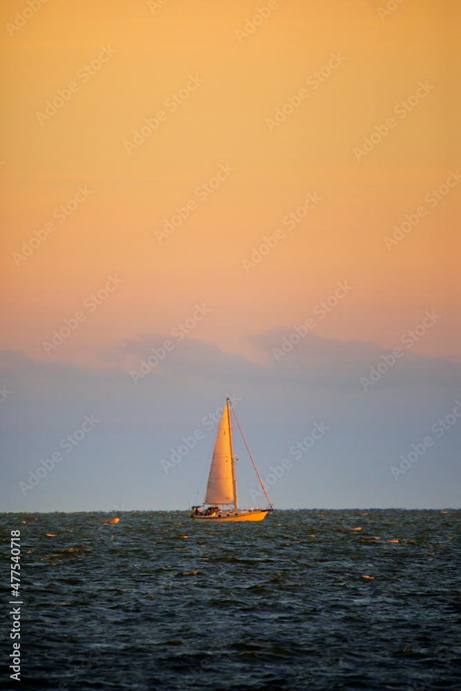 gold and blue sunset with sailboat