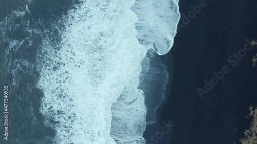 Top down shot of rare black sand beach background, waves hitting volcanic shore, Iceland