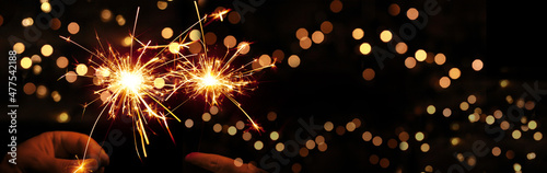 Happy New Year background with glowing sparklers.