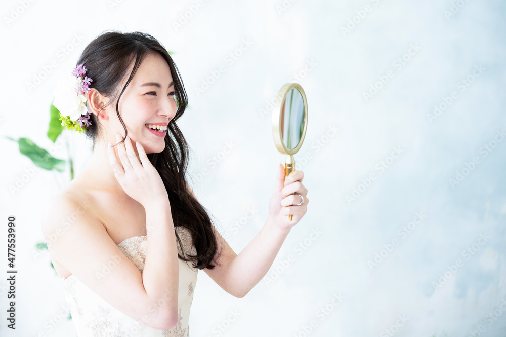 Beautiful Asian bride looking in the mirror and taking care of her skin. Copy space available. Beautiful Asian bride looking in the mirror and taking care of her skin. Copy space available.