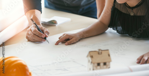 Engineer technicial drawings a house plan on a blueprint. Architects discussing at the table. photo