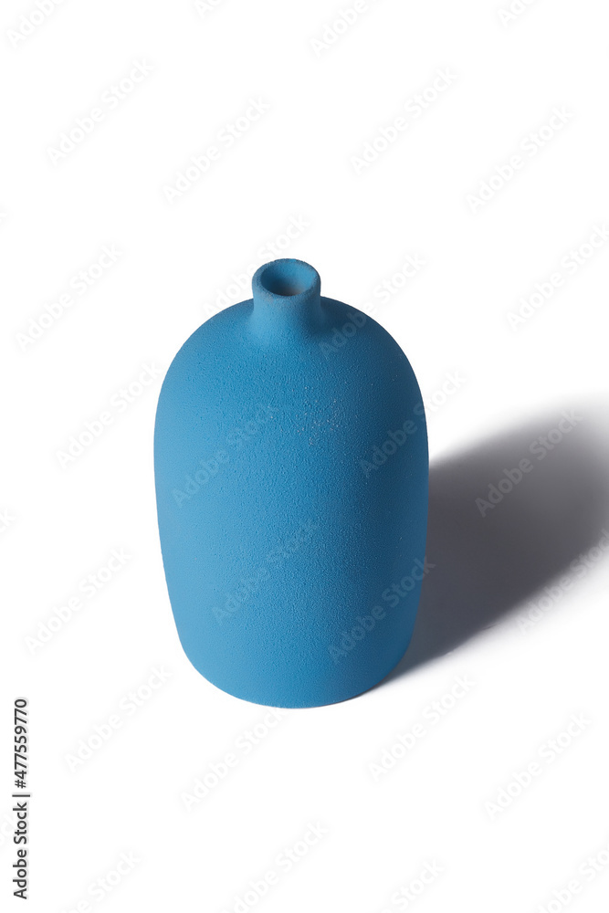 Obraz premium Detailed shot of a blue vase. The vase is tall and large with a narrow neck. The surface of the vase is textured. The blue decor item is isolated on the white background.