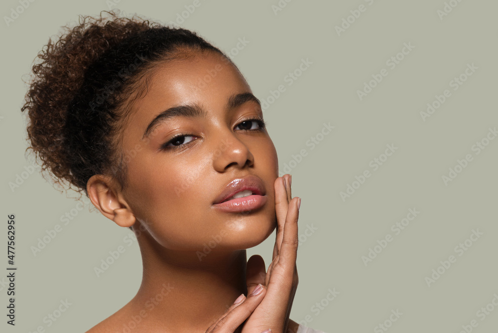 Beauty woman black skin face smiling model touching her face. Color background. Green - obrazy, fototapety, plakaty 