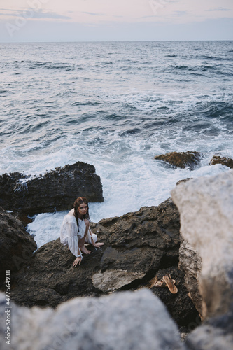 woman on rocky stone in white dress ocean landscape unaltered