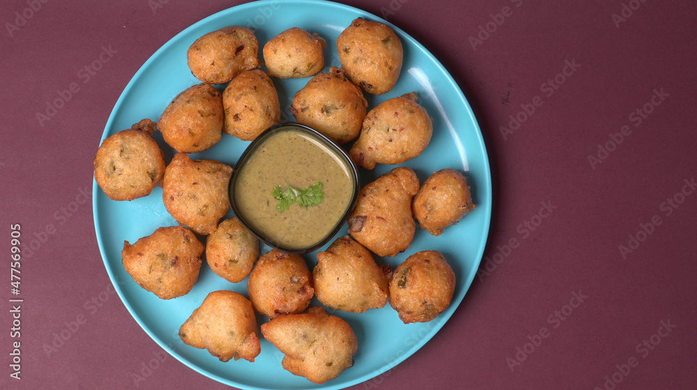 Delicious Indian snacks Punugulu served in a plate with Tomato and green Chutney