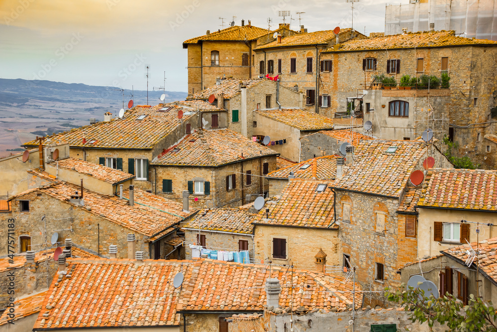 Sunset over old houses on the hilltop village of Volterra, Italy