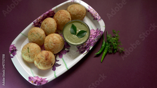 Appum or Appe, Appam or Mixed dal or Rava Appe served with green   chutney. A Ball shape popular south Indian breakfast dish, Selective focus
 photo