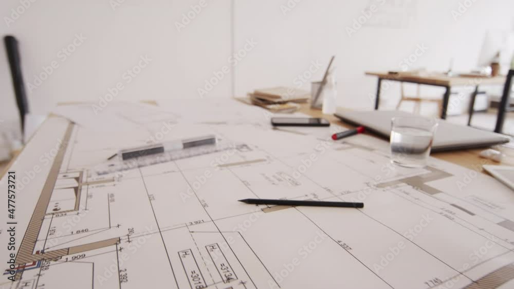 No people shot of house layout, plans and drawings laying on long wooden desk at architects office