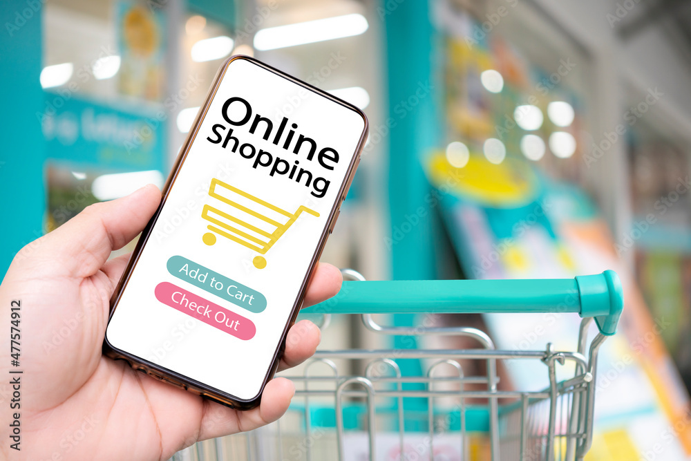 Mobile phone or smartphone with cart shopping cart on background copy space