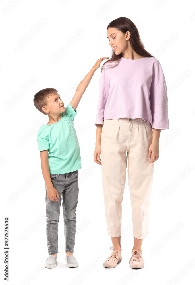 Little boy with his older sister on white background