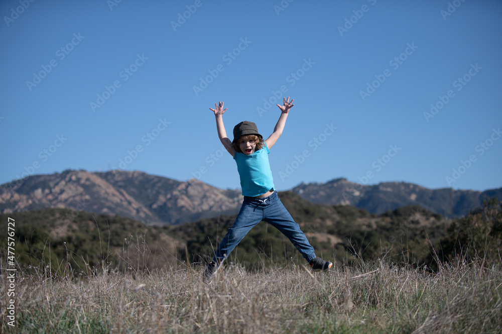 Child camping, happiness and freedom movement kids concept. Excited smiling kid boy jumping.