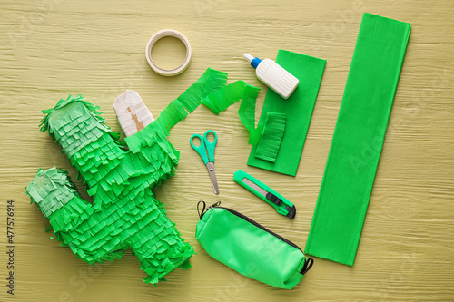 Materials for making Mexican pinata in shape of cactus on color wooden background