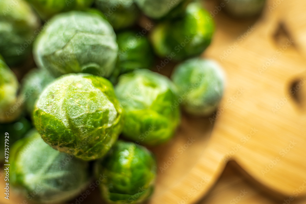 frozen frosty brussels sprouts on wooden plate closeup frozen frosty brussels sprouts on wooden plate closeup