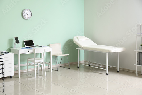 Interior of doctor's office with modern workplace and medical couch