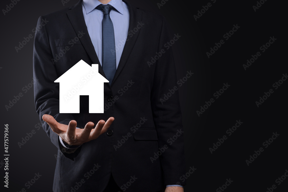 Businessman male hand holding house icon on blue background. Property insurance and security concept.Real estate concept.Banner with copy space. Businessman male hand holding house icon on blue background. Property insurance and security concept.Real estate concept.Banner with copy space.
