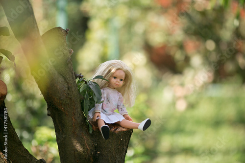 a girl walks in the garden with her favorite doll playing