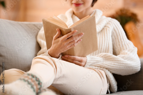 Young woman reading book on...