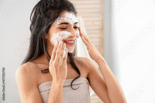 Morning of beautiful young woman washing face in bathroom photo