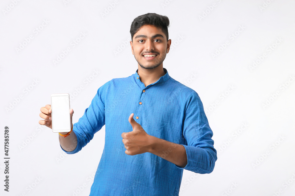 Young indian man showing smartphone screen on white background. Young indian man showing smartphone screen on white background.