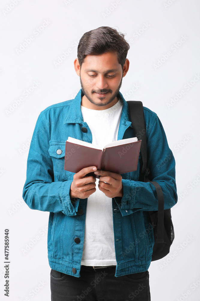 Young Indian college student holding diary in hand on white background. Young Indian college student holding diary in hand on white background.
