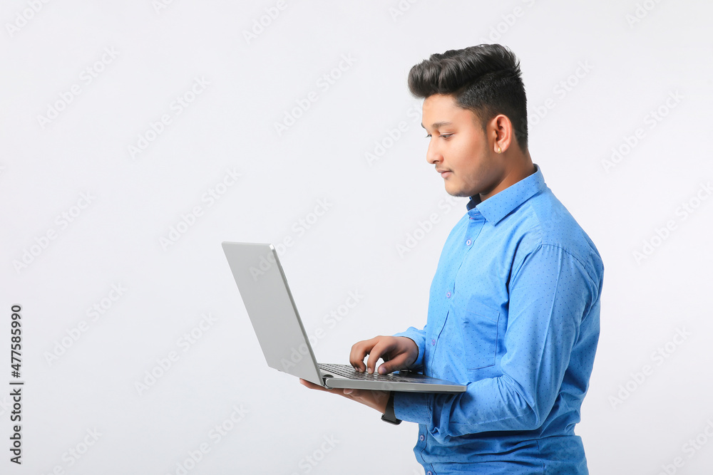 Young indian man using laptop over white background. Young indian man using laptop over white background.