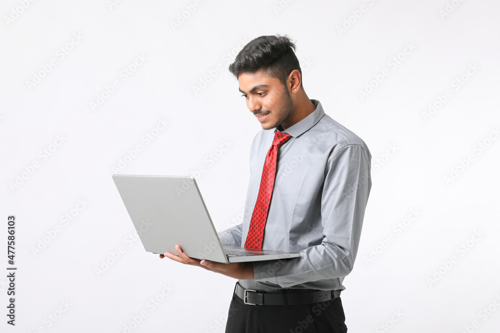 Young indian man using laptop on white background. Young indian man using laptop on white background.
