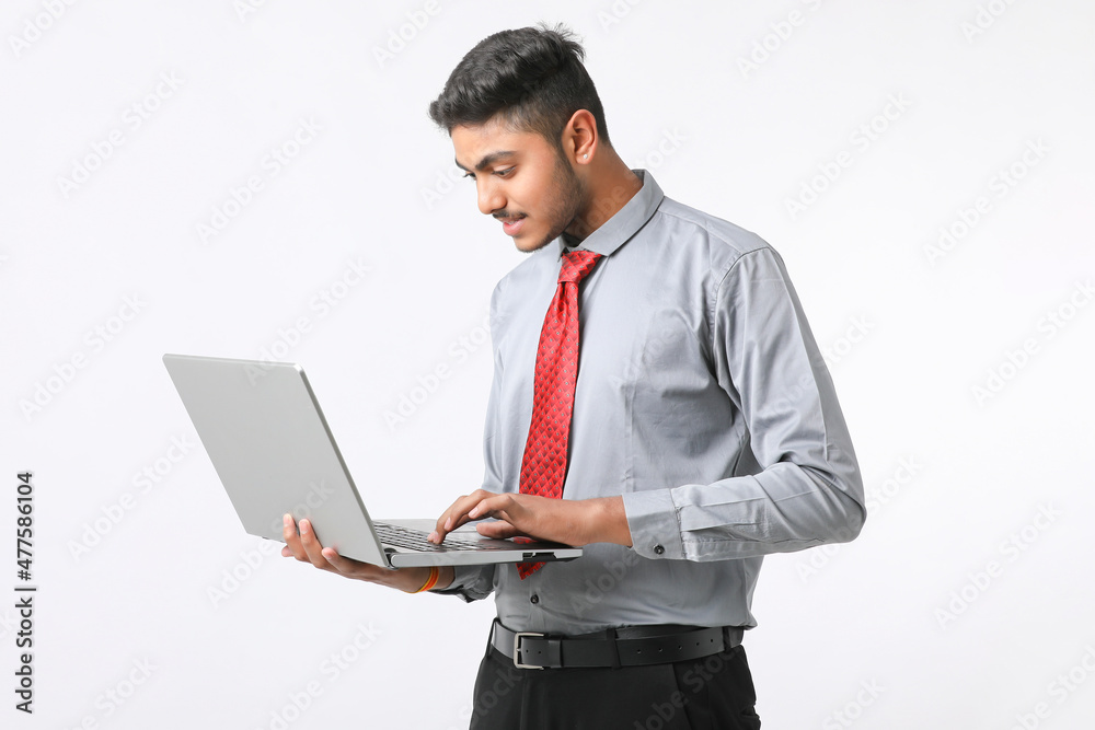 Young indian man using laptop on white background. Young indian man using laptop on white background.