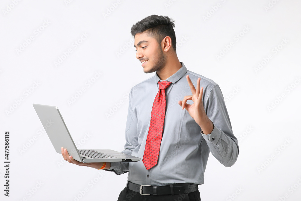 Young indian man using laptop on white background. Young indian man using laptop on white background.
