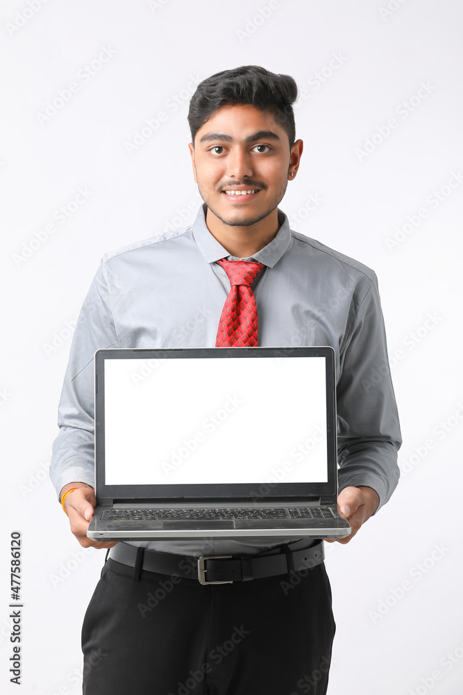 Young indian man showing laptop screen on white background. Young indian man showing laptop screen on white background.
