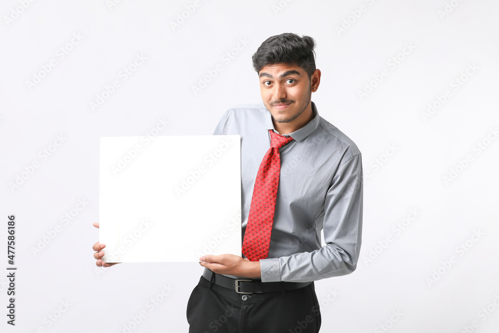 Young Indian business executive showing blank sign board over white background. Young Indian business executive showing blank sign board over white background.