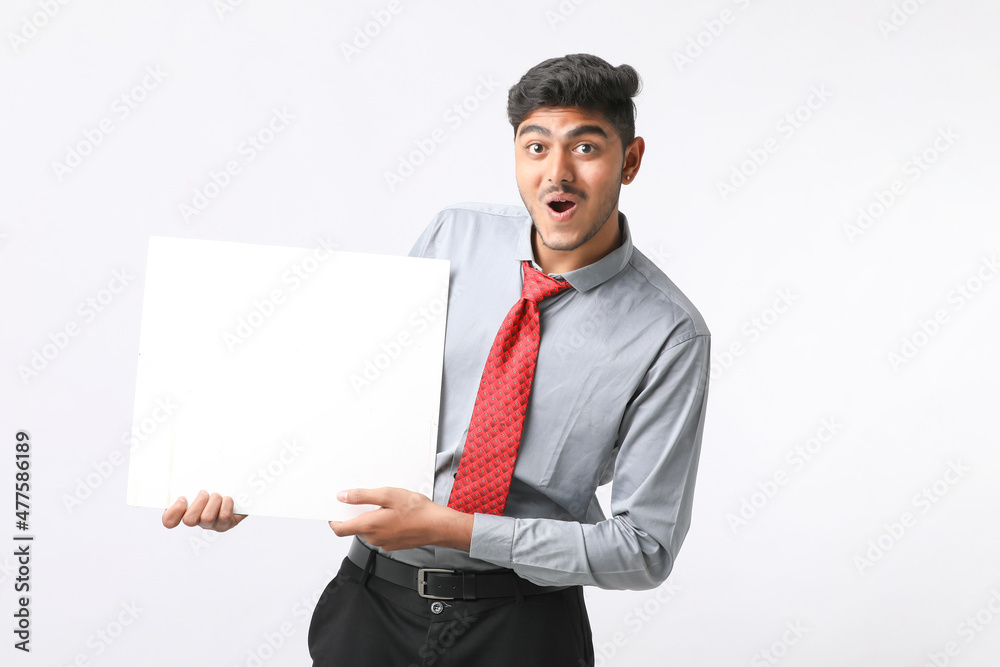 Young Indian business executive showing blank sign board over white background. Young Indian business executive showing blank sign board over white background.